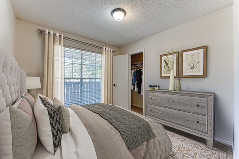 A bedroom with a large bed and a dresser.